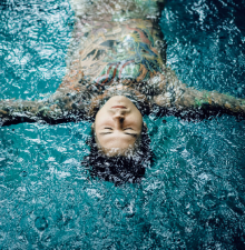 Person floating peacefully in a pool.