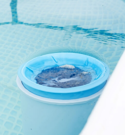 Floating pool skimmer in clear blue water.