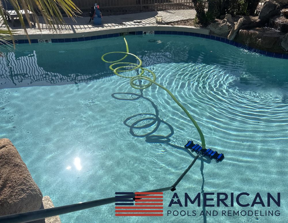 Pool technician vacuuming pool and checking water clarity during weekly pool service in Arizona