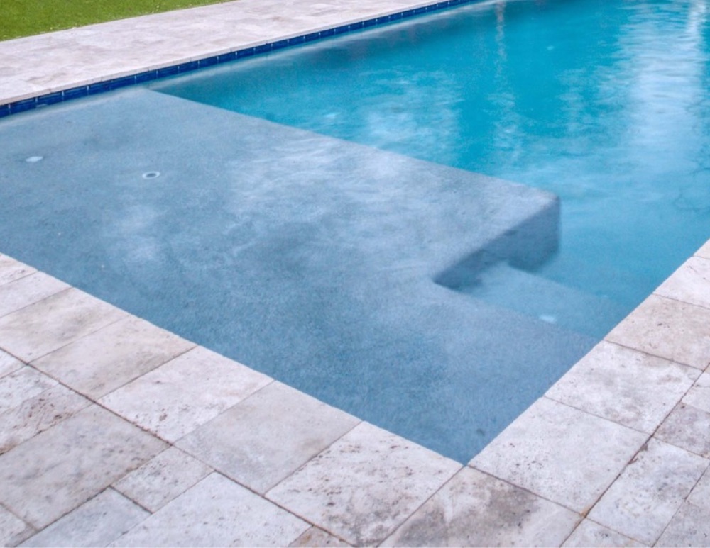 Baja shelf with entry steps in a residential swimming pool