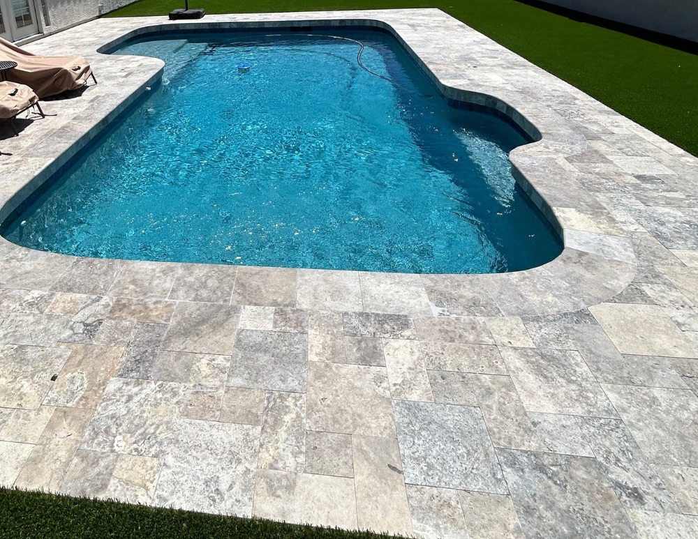 Travertine pool deck and coping installed by American Pools & Remodeling
