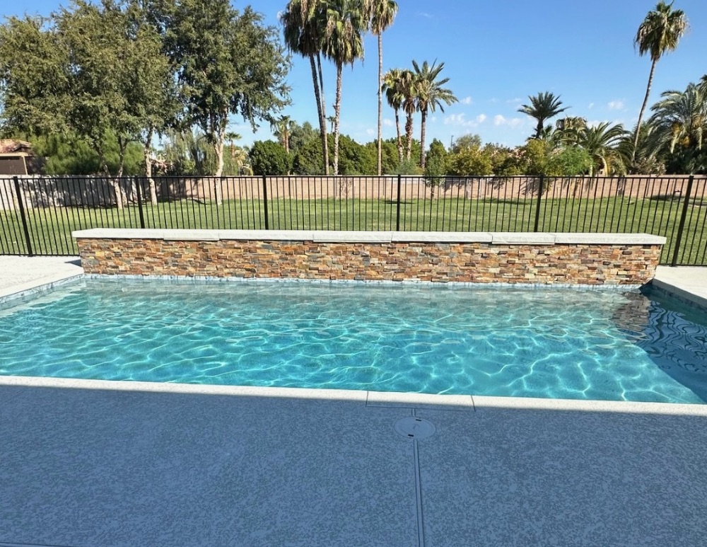 Stone water feature on a pool remodeled by American Pools & Remodeling