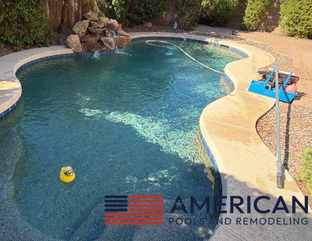 Residential swimming pool with weekly pool service equipment in an Arizona backyard, maintained by American Pools & Remodeling.
